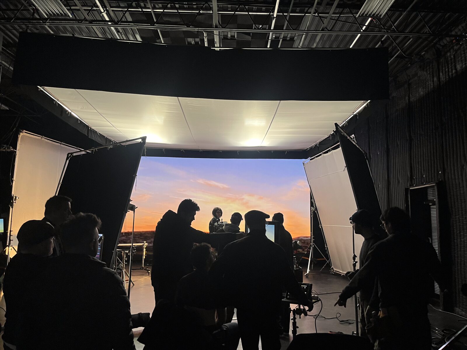 Crew on a sunset stage behind the camera